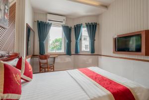 a hotel room with a bed and a tv at Hotel Nhu Y 2 in Ho Chi Minh City