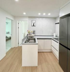a white kitchen with a sink and a refrigerator at 3room+2bathroom hongdae 1exit in Seoul