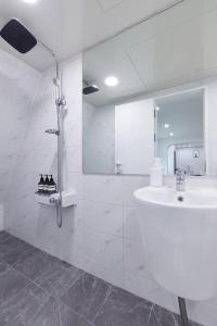 a white bathroom with a sink and a shower at 3room+2bathroom hongdae 1exit in Seoul