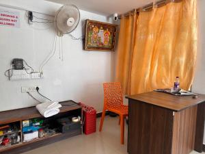 a room with a desk and a chair and a fan at MPS Saai Residency in Tiruvannāmalai