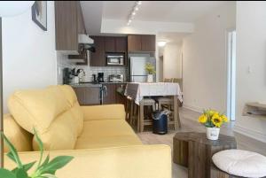 a living room with a yellow couch and a kitchen at YAMA Luxury Condo 2B2B FreeParking in Markham