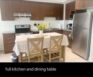 a kitchen with a table and a refrigerator and dining table at YAMA Luxury Condo 2B2B FreeParking in Markham
