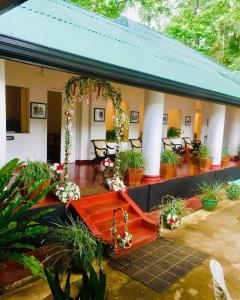 uma casa com um alpendre com vasos de plantas em Heritage Belihuloya Resort em Belihuloya