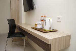 a counter in a room with a coffee maker on it at Hersya Front One Inn Surabaya in Surabaya