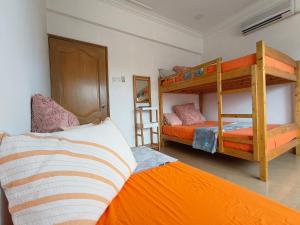 a bedroom with two bunk beds and an orange bed at Kajang Pool Party Villa in Kajang