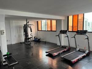 einen Fitnessraum mit Laufbändern und Crosstrainern in einem Zimmer in der Unterkunft Apartamento com vista da praia da Costa 615 in Vila Velha