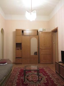 Sala de estar con cama, mesa y espejo en Old Flat Apartments on Belinskogo, en San Petersburgo