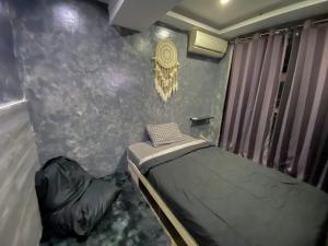 Dormitorio pequeño con cama y pared en Jarrdin Apartment by RumahKu, en Bandung