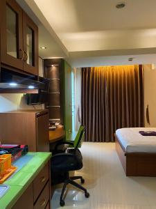 Habitación de hotel con cama, escritorio y habitación en Jarrdin Apartment by RumahKu, en Bandung