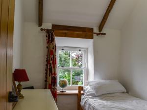 a bedroom with a bed and a window at Bridge Cottage in Porkellis