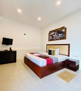 a bedroom with a bed and a tv in it at Hotel Kandyan View ''Free pickup from Kandy city'' in Kandy