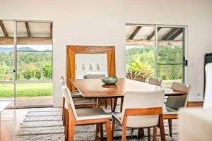 a dining room with a table and chairs and a mirror at The Tree House Bellingen in Thora