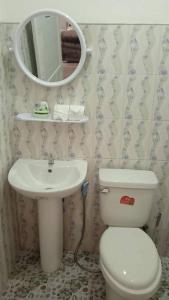 La salle de bains est pourvue de toilettes, d'un lavabo et d'un miroir. dans l'établissement Phujhaofa villa club ( ไสยวน), à Ban Saiyuan (1)