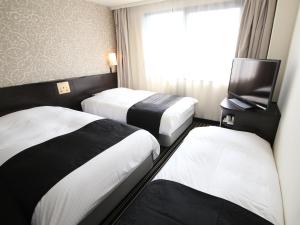 Habitación de hotel con 2 camas y TV de pantalla plana. en APA Hotel Tokyo Kiba, en Tokio
