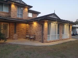 a brick house with a patio in front of it at Luxurious Countryside Retreat - Visit our private apartment on our acreage property! in Park Ridge