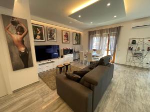uma sala de estar com um sofá e uma televisão em Eur Baldovinetti Luxury Suite Vicino IFAD, Huawei, Eni, Zte, Unilever, Siemens, Open Fiber em Roma