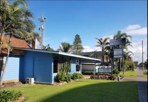 a blue building with a sign in front of it at Golden Sands Motor Inn in Forster