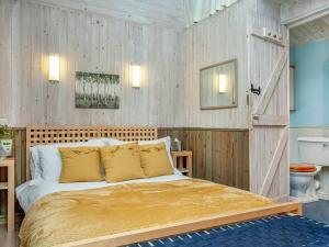 ein Schlafzimmer mit einem Bett mit einer Holzwand in der Unterkunft Laughing Waters in Chillaton