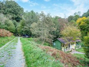 a small house on a hill next to a dirt road at Laughing Waters in Chillaton