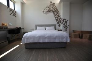台南的住宿－樂宿保安 No.1 ，卧室配有一张壁挂长颈鹿头的床