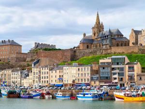 a group of boats docked in a harbor with a castle at Holiday Home in Normandy near Sandy Beach in Hauteville-sur-Mer