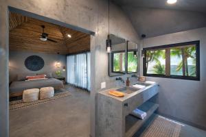 un bagno con un lavandino e un letto in una stanza di Arca a West Bay