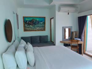 een slaapkamer met een groot wit bed en een bank bij Villa Giyor in Nusa Lembongan