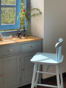 a white chair sitting next to a kitchen counter at Triền Thông An Nhiên Đà Lạt Rừng Trong Phố in Da Lat