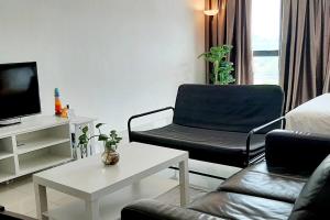 un soggiorno con divano, sedia e TV di mozhouze studio @ 8 Kinrara Service Apartment a Puchong