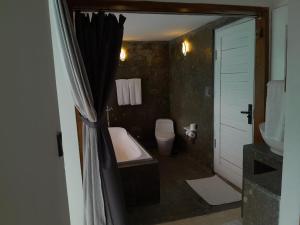 a bathroom with a bath tub and a toilet at Villa Giyor in Nusa Lembongan