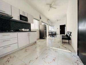 曼萨尼约Casa Completa en Real del Country Alberca y Playa的一间大厨房,配有白色的橱柜和一张桌子