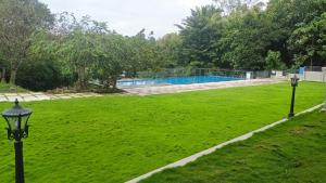 a green field with two lights in the grass at Saugandhika West Gate in Wayanad