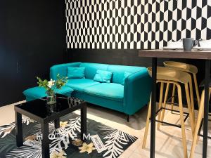um sofá azul numa sala de estar com uma mesa em Vivo Contemporary Style Studio/5PX Near Mid Valley em Kuala Lumpur