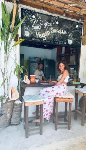 a woman sitting at a table outside of a restaurant at Wave Heaven 9 meters to cloud 9 in General Luna