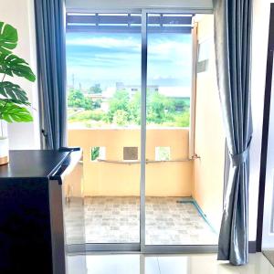 a room with a sliding glass door with a view at MY HOME Hotel - Phutthamonthon 4 Road, near Mahidol University Salaya in Ban Krathum Lom