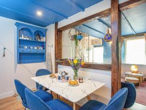 a dining room with blue ceilings and a table with blue chairs at Gypsett in Polruan