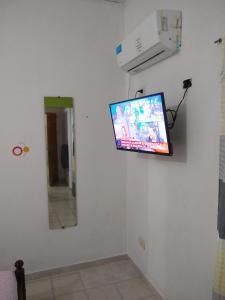 einen Flachbild-TV an der Wand in einem Zimmer in der Unterkunft Naiguata in Zárate