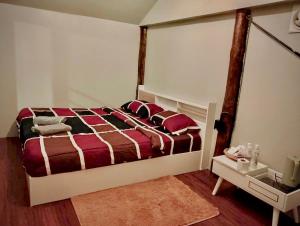 a bedroom with a large bed with red and brown sheets at Father's Garden Inthanon in Ban Na Yang