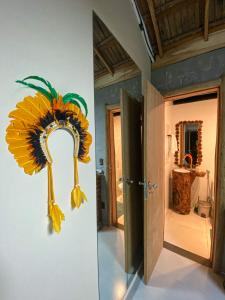 a large sunflower decoration on the wall of a bathroom at Suítes Naldiane in Imbassai