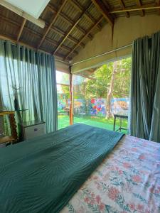 a bedroom with a bed and a large window at Suítes Naldiane in Imbassai