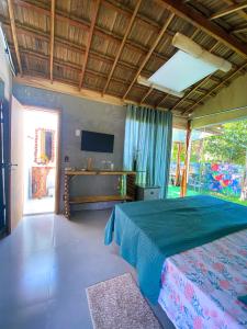 a bedroom with a large bed and a television at Suítes Naldiane in Imbassai