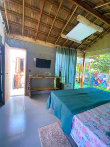 a bedroom with a large bed and a television at Suítes Naldiane in Imbassai +117 photos