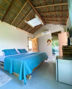ein Schlafzimmer mit einem blauen Bett in einem Zimmer in der Unterkunft Suítes Naldiane in Imbassai
