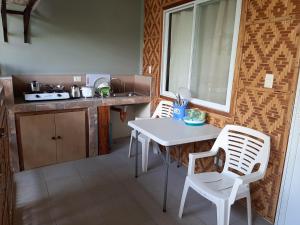 a kitchen with a table and two chairs and a counter at Alimpay Foresters Apartment in Panglao
