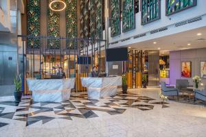 a lobby with two people in a building at THE 1O1 Jakarta Airport CBC in Tangerang