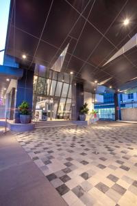 an empty lobby of a building with a checkered floor at THE 1O1 Jakarta Airport CBC in Tangerang