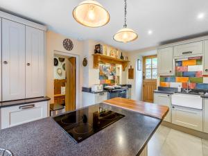 a kitchen with white cabinets and a black counter top at Forge Cottage in Carlton