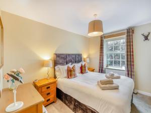 a bedroom with a large bed and a window at Forge Cottage in Carlton