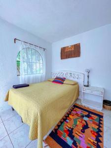a bedroom with a bed and a rug on the floor at El Castillo en el Lago Atitlán in San Marcos La Laguna