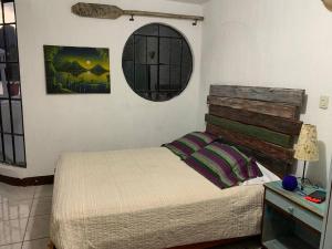 a bedroom with a bed and a mirror on the wall at El Castillo en el Lago Atitlán in San Marcos La Laguna